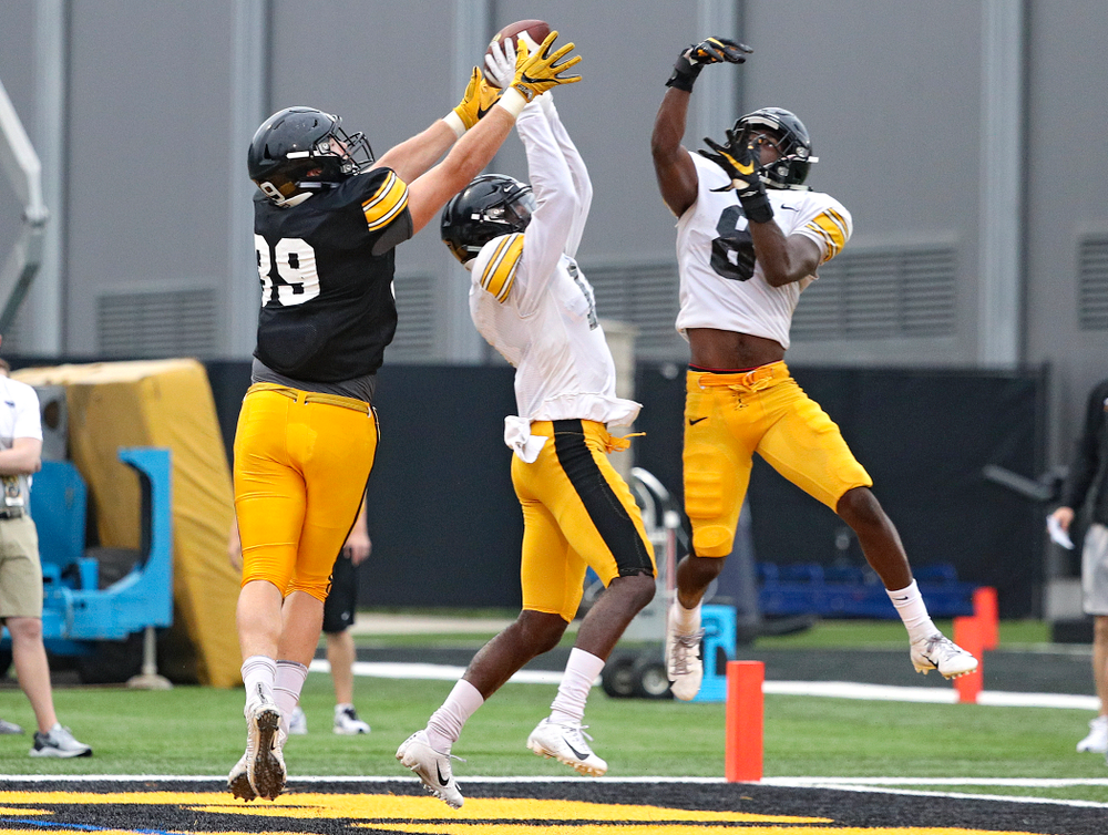 Iowa Hawkeyes defensive back Michael Ojemudia (center) intercepts a pass intended for tight end Nate Wieting (left) after it cleared the hands of defensive back Matt Hankins (8) durning Fall Camp Practice No. 17 at the Hansen Football Performance Center in Iowa City on Wednesday, Aug 21, 2019. (Stephen Mally/hawkeyesports.com)