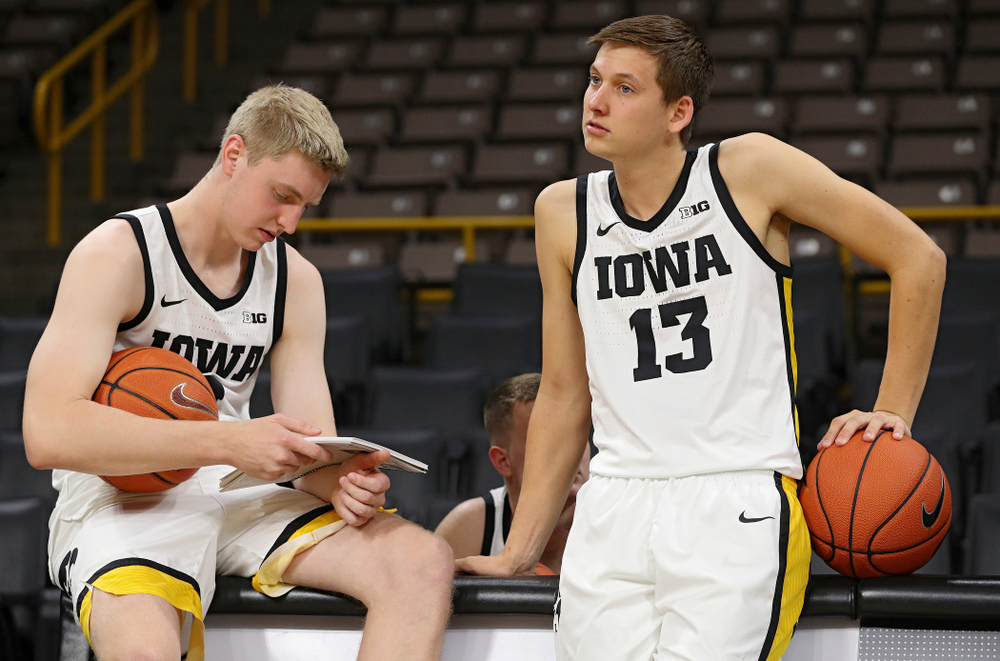 Iowa Hawkeyes forward Michael Baer (0) reads a media guide as guard Austin Ash (13) looks on during Iowa Men’s Basketball Media Day at Carver-Hawkeye Arena in Iowa City on Wednesday, Oct 9, 2019. (Stephen Mally/hawkeyesports.com)