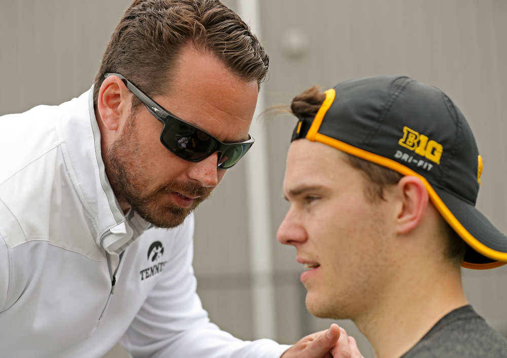 Iowa head coach Ross Wilson (from left) talks with Jonas Larsen during a match against Ohio State at the Hawkeye Tennis and Recreation Complex in Iowa City on Sunday, Apr. 7, 2019. (Stephen Mally/hawkeyesports.com)