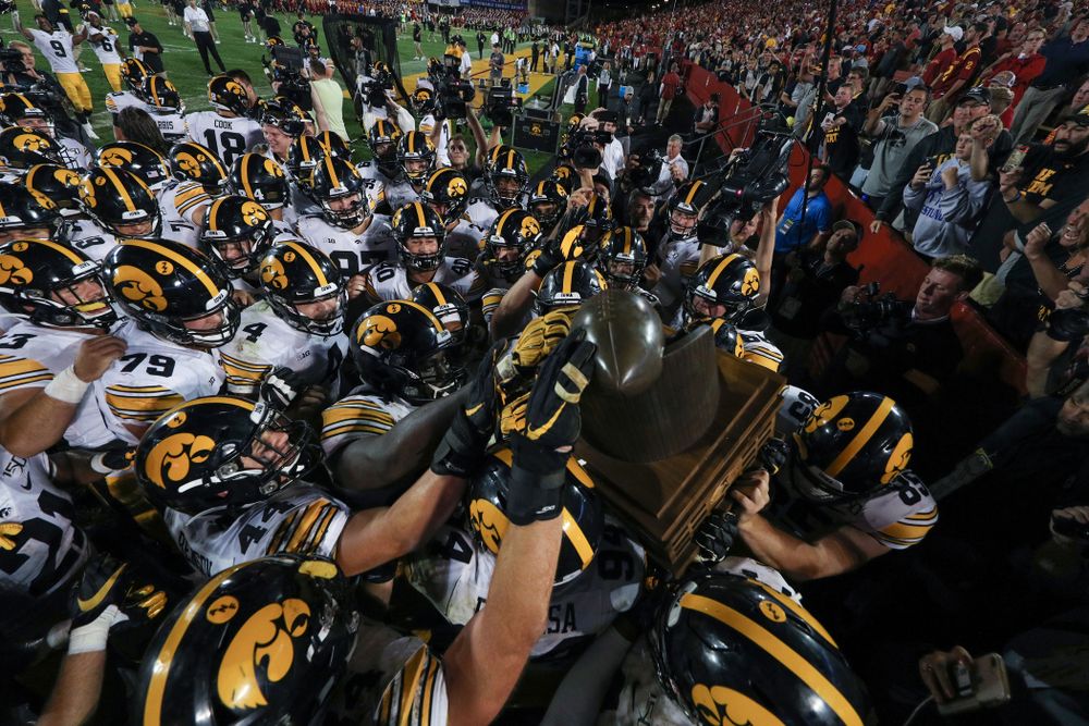 The Iowa Hawkeyes swarm to the Cy-Hawk trophy following their game against the Iowa State Cyclones Saturday, September 14, 2019 in Ames, Iowa. (Brian Ray/hawkeyesports.com)