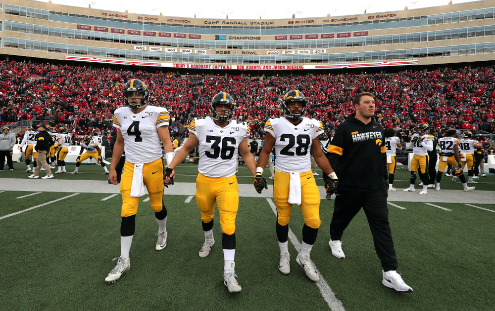 Iowa Hawkeyes captains quarterback Nate Stanley (4), fullback Brady Ross (36), running back Toren Young (28), and linebacker Kristian Welch (34) walk out for the coin toss against the Wisconsin Badgers Saturday, November 9, 2019 at Camp Randall Stadium in Madison, Wisc. (Brian Ray/hawkeyesports.com)