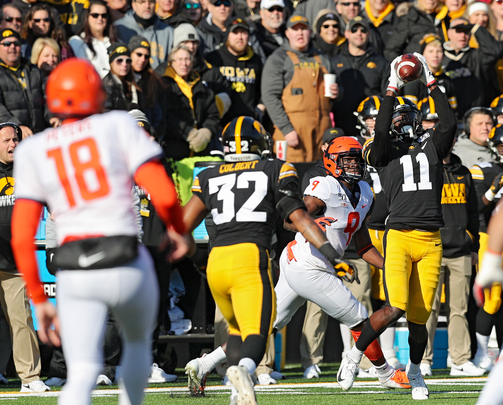 Iowa Hawkeyes defensive back Michael Ojemudia (11) intercepts a pass from Illinois Fighting Illini quarterback Brandon Peters (18) during the first quarter of their game at Kinnick Stadium in Iowa City on Saturday, Nov 23, 2019. (Stephen Mally/hawkeyesports.com)
