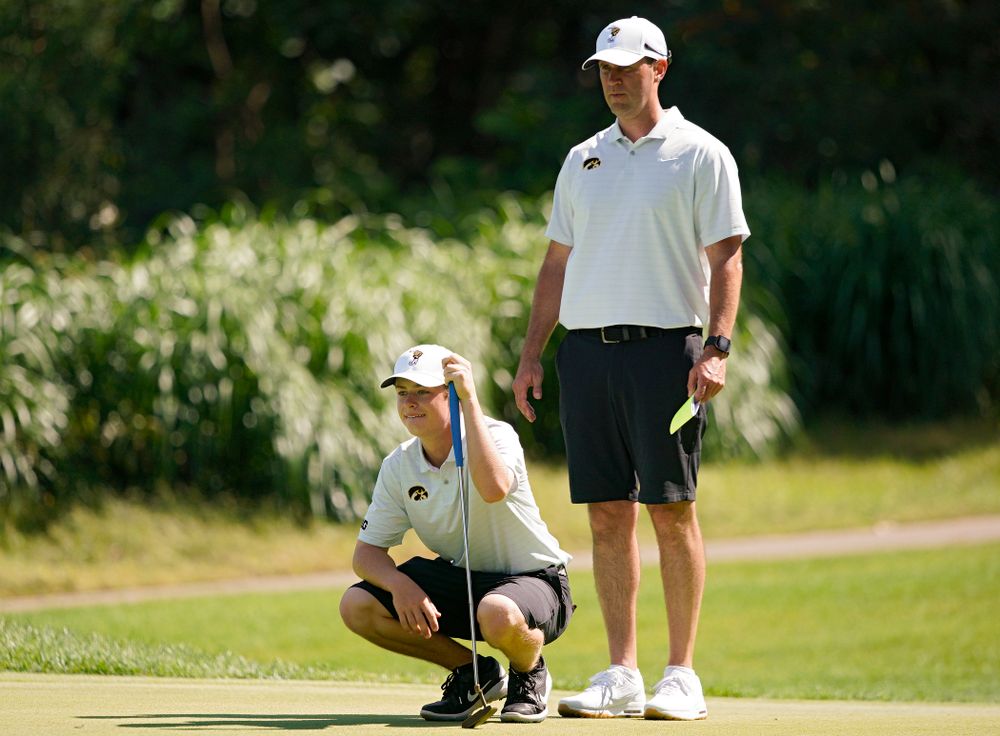 Iowa’s Matthew Garside (from left) lines up a putt as head coach Tyler Stith looks on during the second day of the Golfweek Conference Challenge at the Cedar Rapids Country Club in Cedar Rapids on Monday, Sep 16, 2019. (Stephen Mally/hawkeyesports.com)