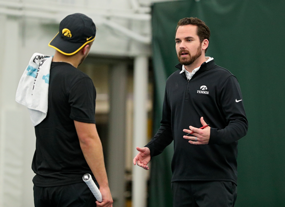 Iowa’s Will Davies (from left) talks with head coach Ross Wilson during their match at the Hawkeye Tennis and Recreation Complex in Iowa City on Thursday, January 16, 2020. (Stephen Mally/hawkeyesports.com)