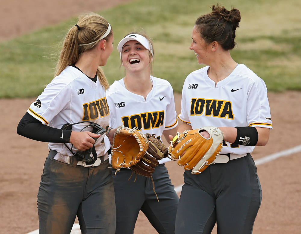 Iowa Hawkeyes Allison Doocy (from left), Hallie Ketcham (22), and Mallory Kilian (11) share a laugh during the fifth inning of their Big Ten Conference softball game at Pearl Field in Iowa City on Friday, Mar. 29, 2019. (Stephen Mally/hawkeyesports.com)