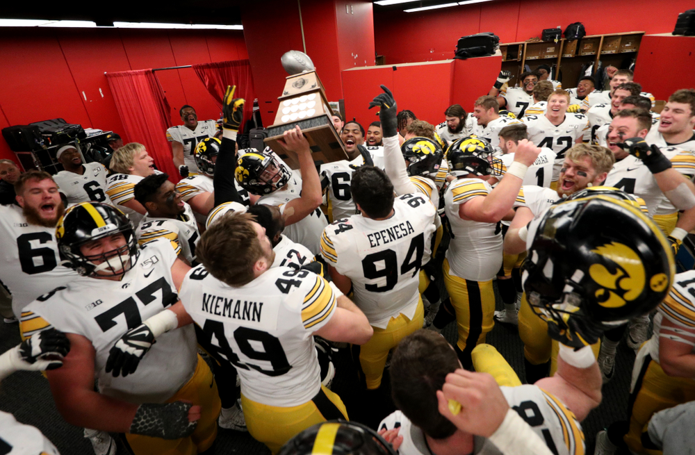 Iowa Hawkeyes quarterback Nate Stanley (4) hoists the Heroes Game trophy as they celebrate their win against the Nebraska Cornhuskers Friday, November 29, 2019 at Memorial Stadium in Lincoln, Neb. (Brian Ray/hawkeyesports.com)