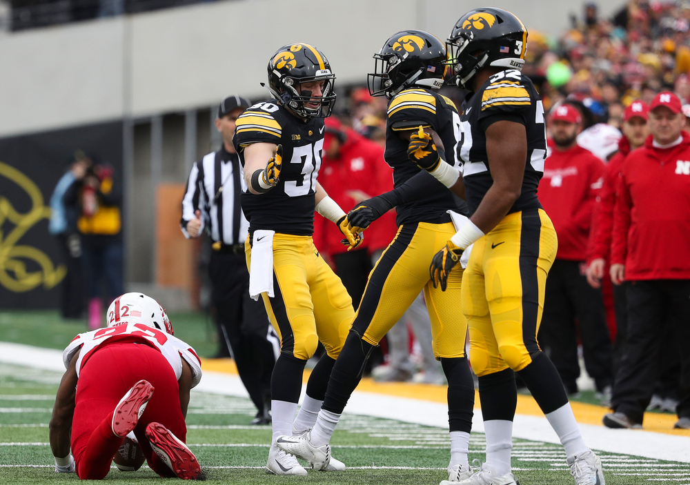 Iowa Hawkeyes defensive back Jake Gervase (30) congratulates Iowa Hawkeyes defensive back Matt Hankins (8) after Hankins made a tackle