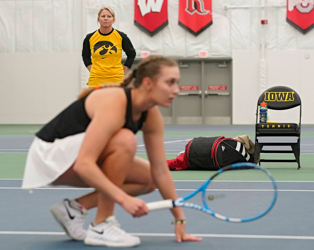 Iowa head coach Sasha Schmid (top) looks on as Ashleigh Jacobs ducks during a serve in their doubles match against Indiana at the Hawkeye Tennis and Recreation Complex in Iowa City on Sunday, Mar. 31, 2019. (Stephen Mally/hawkeyesports.com)