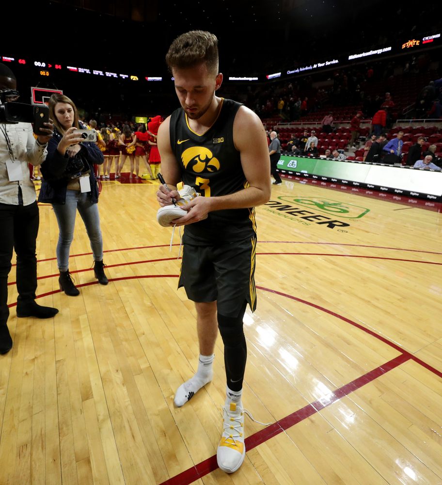 Iowa Hawkeyes guard Jordan Bohannon (3) writes a message on his shoes before leaving them on the court following their game against the Iowa State Cyclones Thursday, December 12, 2019 at Hilton Coliseum in Ames, Iowa(Brian Ray/hawkeyesports.com)