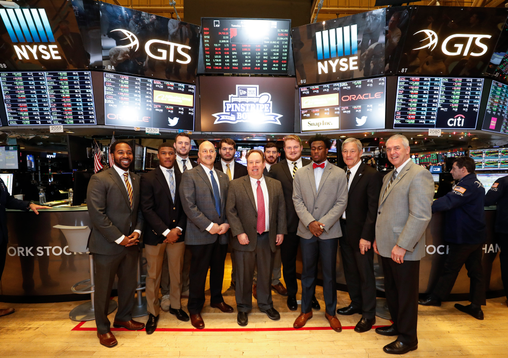 Iowa Hawkeyes linebacker Josey Jewell (43), defensive back Joshua Jackson (15), offensive lineman Sean Welsh (79) and head coach Kirk Ferentz ring the opening bell at the New York Stock Exchange Tuesday, December 26, 2017 in New York. (Brian Ray/hawkeyesports.com)