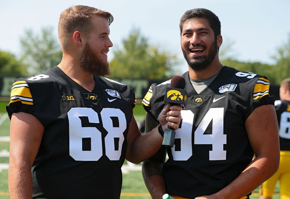 Iowa Hawkeyes offensive lineman Landan Paulsen (68) interviews defensive end A.J. Epenesa (94) during Iowa Football Media Day at the Hansen Football Performance Center in Iowa City on Friday, Aug 9, 2019. (Stephen Mally/hawkeyesports.com)