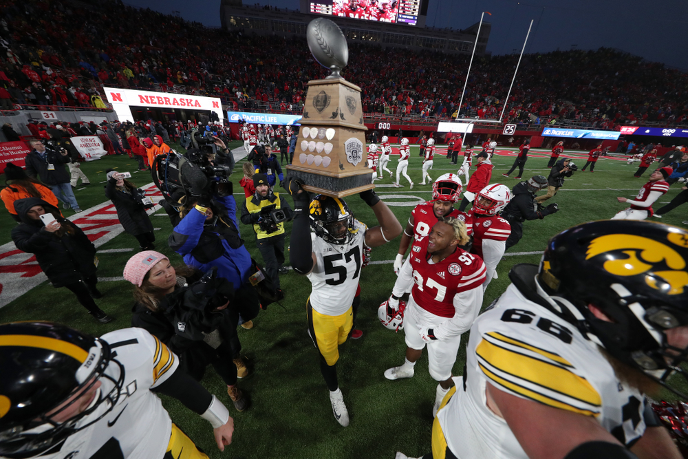 Iowa Hawkeyes defensive end Chauncey Golston (57) carries the Heroes Game trophy off the field following their win against the Nebraska Cornhuskers Friday, November 29, 2019 at Memorial Stadium in Lincoln, Neb. (Brian Ray/hawkeyesports.com)