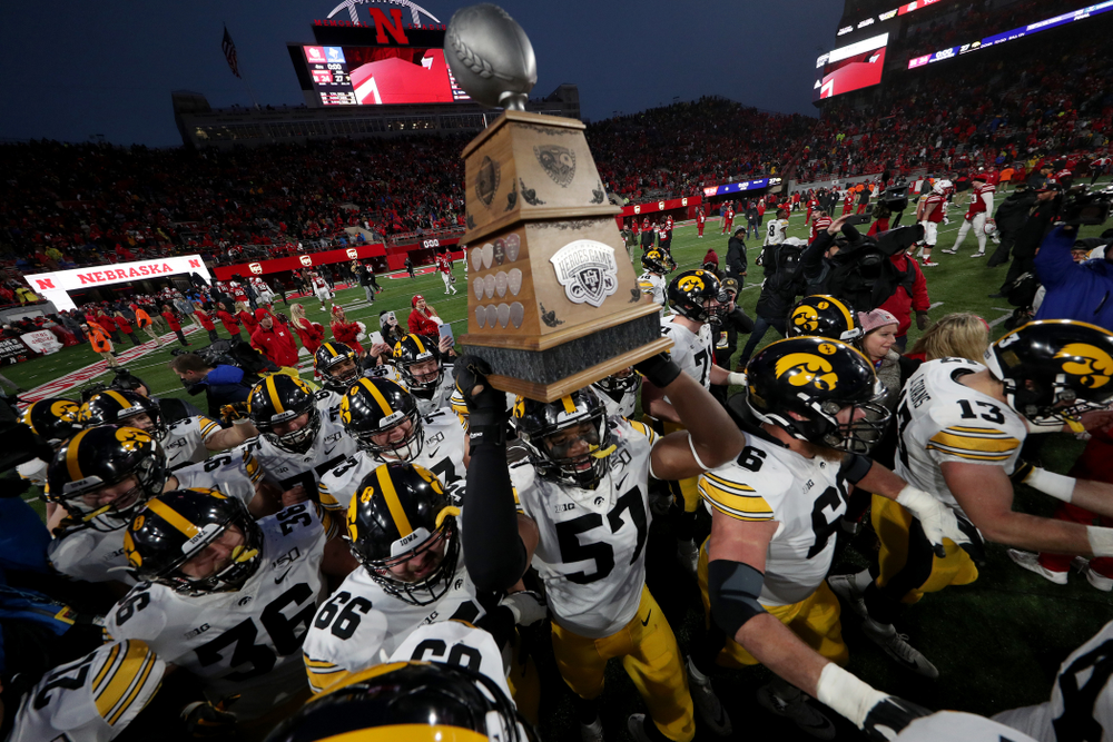 Iowa Hawkeyes defensive end Chauncey Golston (57) carries the Heroes Game trophy off the field following their win against the Nebraska Cornhuskers Friday, November 29, 2019 at Memorial Stadium in Lincoln, Neb. (Brian Ray/hawkeyesports.com)