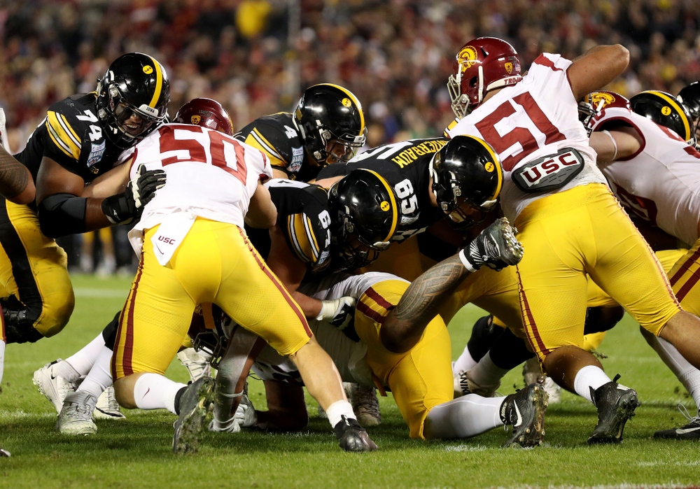 Iowa Hawkeyes offensive lineman Tyler Linderbaum (65) leads the way for quarterback Nate Stanley (4) against USC in the Holiday Bowl Friday, December 27, 2019 at San Diego Community Credit Union Stadium. (Brian Ray/hawkeyesports.com)