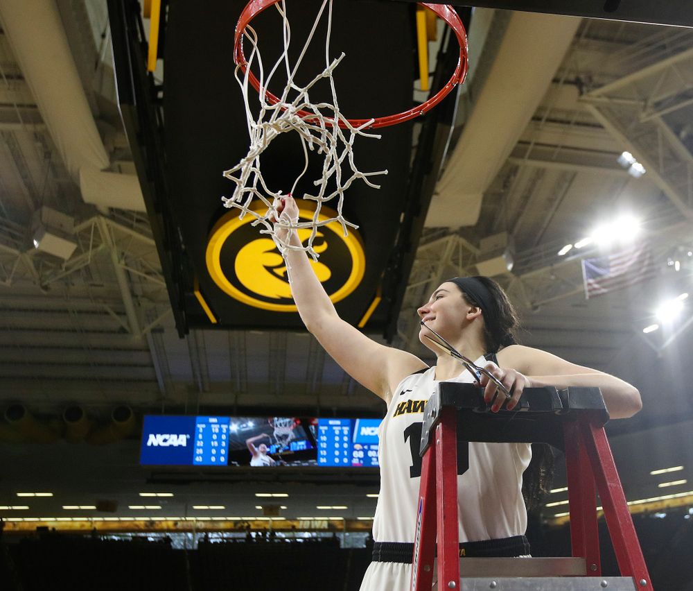 Iowa Hawkeyes center Megan Gustafson (10) cuts down the net after winning their second round game in the 2019 NCAA Women's Basketball Tournament at Carver Hawkeye Arena in Iowa City on Sunday, Mar. 24, 2019. (Stephen Mally for hawkeyesports.com)