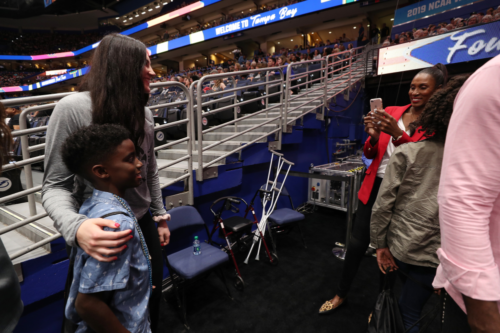 Iowa Hawkeyes forward Megan Gustafson (10) talks with Lisa Leslie and her family before being introduced during a timeout in the second half of the National Semi-Final between Baylor and Oregon Friday, April 5, 2019 at Amalie Arena in Tampa, FL. (Brian Ray/hawkeyesports.com)