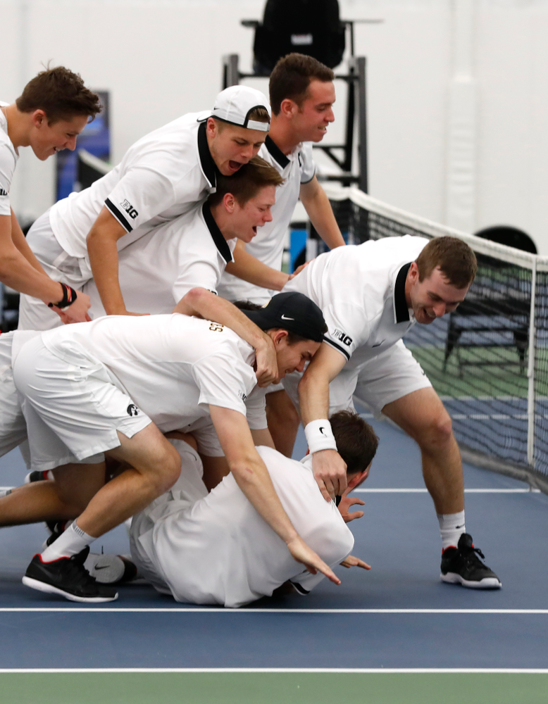 Iowa's Piotr Smietana celebrates with his teammates after clinching the match against Purdue Sunday, April 15, 2018 at the Hawkeye Tennis an