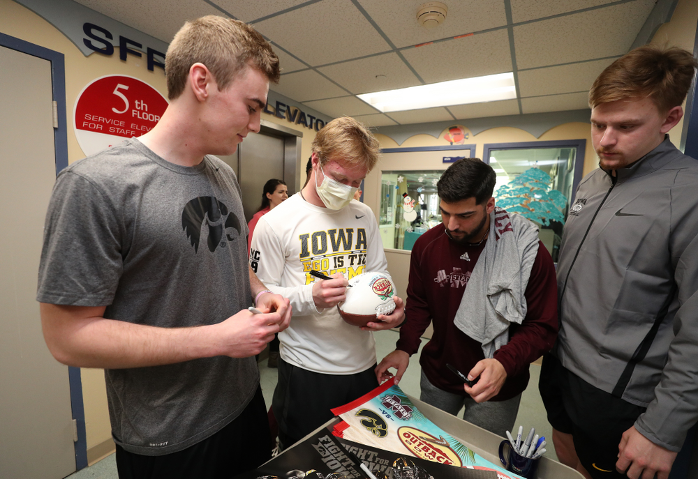 Iowa Hawkeyes punter Ryan Gersonde (2), wide receiver Max Cooper (19), and quarterback Spencer Petras (7) sign autographs for patients during a visit to Tampa General Hospital as part of the Outback Bowl Friday, December 28, 2018 in Tampa, FL.(Brian Ray/hawkeyesports.com)
