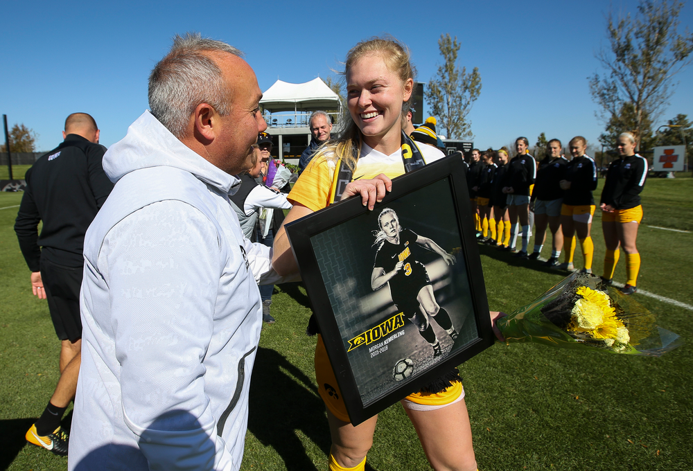 Iowa Hawkeyes head coach Dave DiIanni presents Iowa Hawkeyes defender Morgan Kemerling (3) with a framed photo during Senior Day ceremonies before a game against Northwestern at the Iowa Soccer Complex on October 21, 2018. (Tork Mason/hawkeyesports.com)
