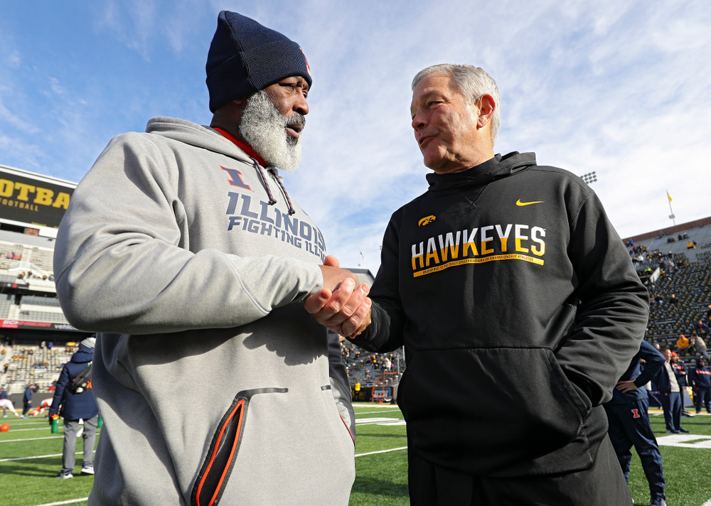 Illinois Fighting Illini head coach Lovie Smith (from left) and Iowa Hawkeyes head coach Kirk Ferentz shake hands before their game at Kinnick Stadium in Iowa City on Saturday, Nov 23, 2019. (Stephen Mally/hawkeyesports.com)