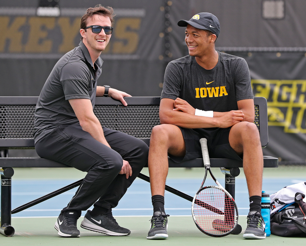 Iowa assistant coach Joey Manilla (from left) talks with Oliver Okonkwo during a match against Ohio State at the Hawkeye Tennis and Recreation Complex in Iowa City on Sunday, Apr. 7, 2019. (Stephen Mally/hawkeyesports.com)