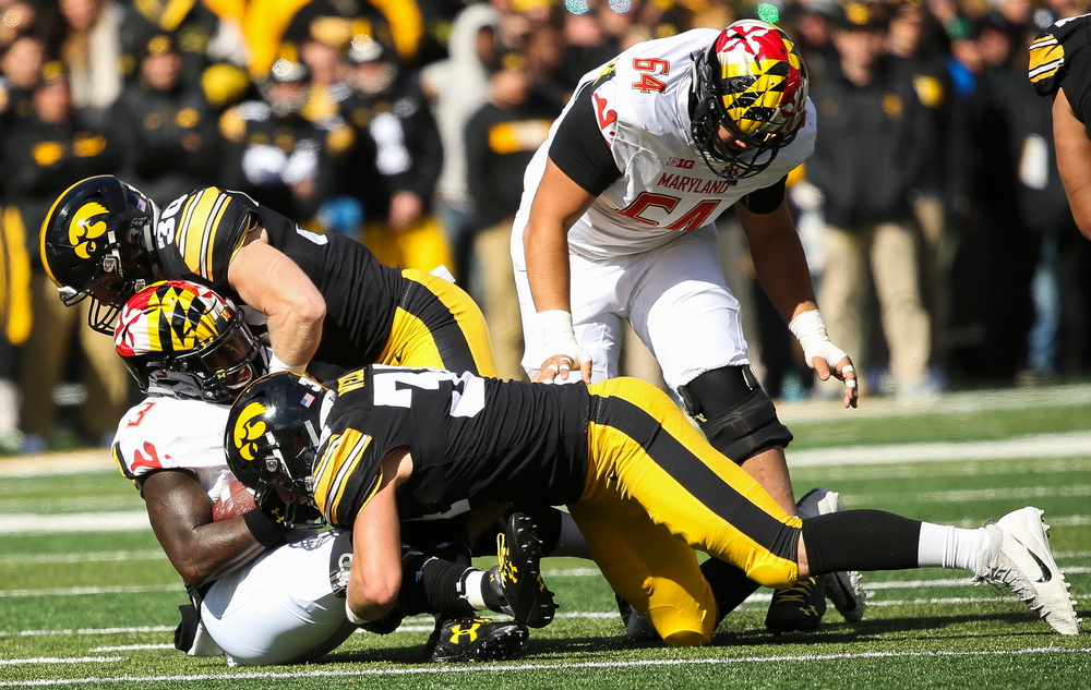 Iowa Hawkeyes defensive back Jake Gervase (30) and Iowa Hawkeyes linebacker Kristian Welch (34) make a tackle during a game against Maryland at Kinnick Stadium on October 20, 2018. (Tork Mason/hawkeyesports.com)