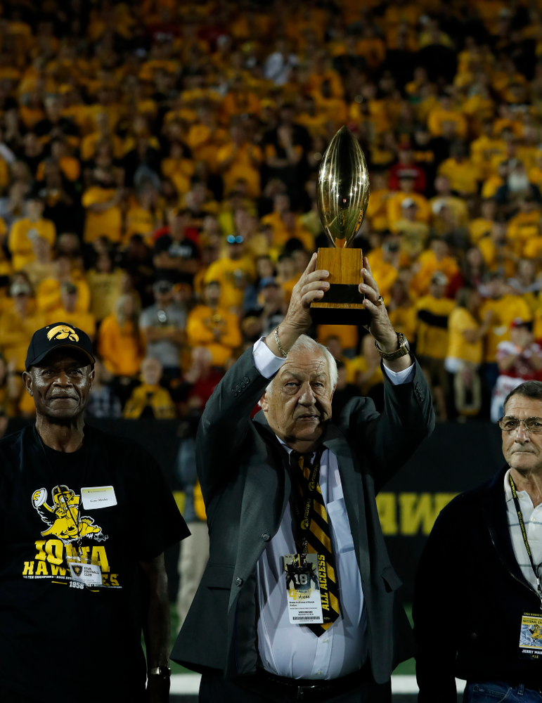 Tom Moore holds up the 19058 National Championship trophy as the team is introduced during the Iowa Hawkeyes game against the Wisconsin Badgers Saturday, September 22, 2018 at Kinnick Stadium. (Brian Ray/hawkeyesports.com)