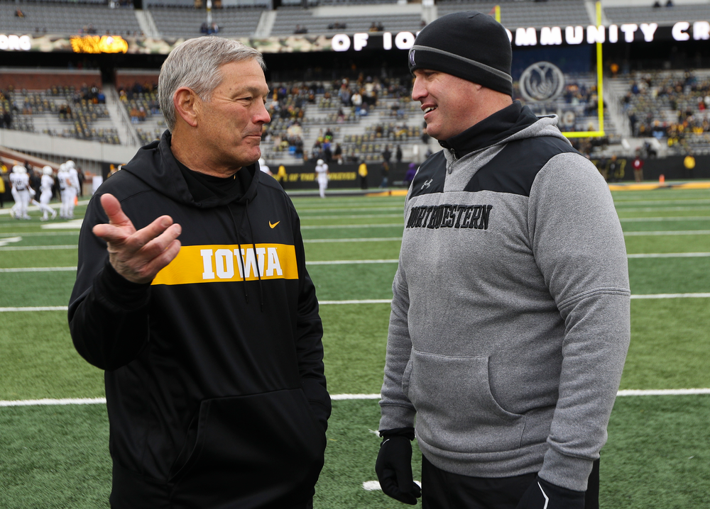 Iowa Hawkeyes head coach Kirk Ferentz talks with Northwestern Wildcats head coach Pat Fitzgerald before a game against Northwestern at Kinnick Stadium on November 10, 2018. (Tork Mason/hawkeyesports.com)