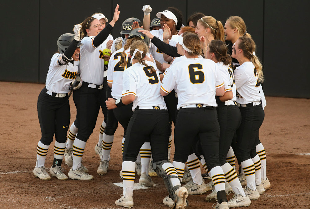 Iowa designated player Miranda Schulte (20) is greeted by teammates at home plate after hitting a home run during the sixth inning of their game against Ohio State at Pearl Field in Iowa City on Friday, May. 3, 2019. (Stephen Mally/hawkeyesports.com)