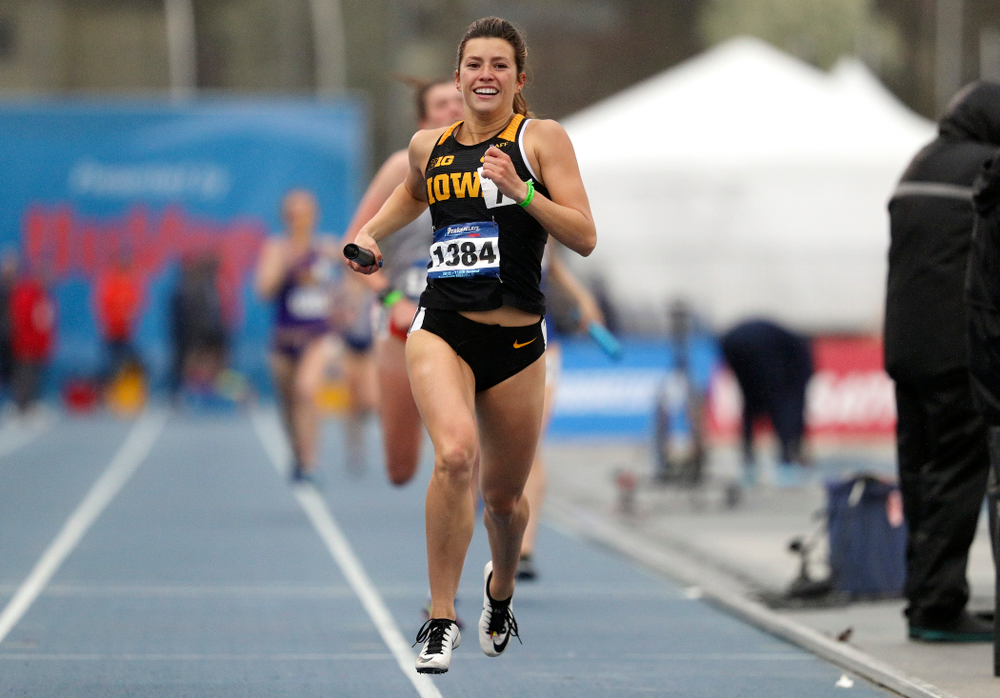 Iowa's Taylor Arco smiles as she nears the finish line while running the women's sprint medley relay event during the third day of the Drake Relays at Drake Stadium in Des Moines on Saturday, Apr. 27, 2019. (Stephen Mally/hawkeyesports.com)