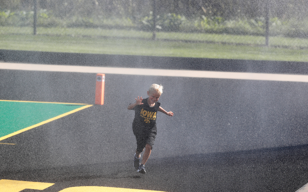 A young boy plays in the sprinklers as the field is watered at half time of the Iowa Hawkeyes game against the Penn Quakers Friday, September 14, 2018 at Grant Field. (Brian Ray/hawkeyesports.com)
