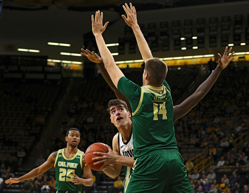 Iowa Hawkeyes center Luka Garza (55) eyes the basket around Cal Poly Mustangs forward Tuukka Jaakkola (14) during the first half of their game at Carver-Hawkeye Arena in Iowa City on Sunday, Nov 24, 2019. (Stephen Mally/hawkeyesports.com)