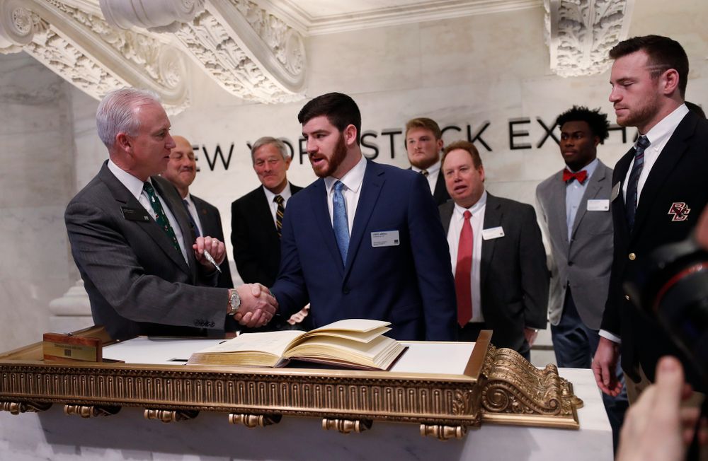 Iowa Hawkeyes linebacker Josey Jewell (43), defensive back Joshua Jackson (15), offensive lineman Sean Welsh (79) and head coach Kirk Ferentz ring the opening bell at the New York Stock Exchange Tuesday, December 26, 2017 in New York. (Brian Ray/hawkeyesports.com)