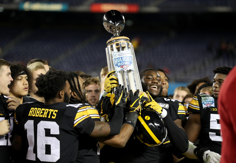 Iowa Hawkeyes defensive tackle Daviyon Nixon (54) holds the Holiday Bowl trophy following their win against USC in the Holiday Bowl Friday, December 27, 2019 at San Diego Community Credit Union Stadium. (Brian Ray/hawkeyesports.com)