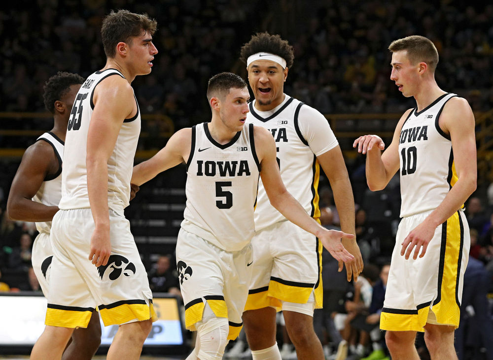 Iowa Hawkeyes guard CJ Fredrick (5) is greeted by guard Joe Toussaint (1), center Luka Garza (55), forward Cordell Pemsl (35), and guard Joe Wieskamp (10) after making a 3-pointer while being fouled during the second half of their game at Carver-Hawkeye Arena in Iowa City on Sunday, Nov 24, 2019. (Stephen Mally/hawkeyesports.com)