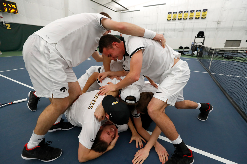 Iowa's Piotr Smietana celebrates with his teammates after clinching the match against Purdue Sunday, April 15, 2018 at the Hawkeye Tennis an