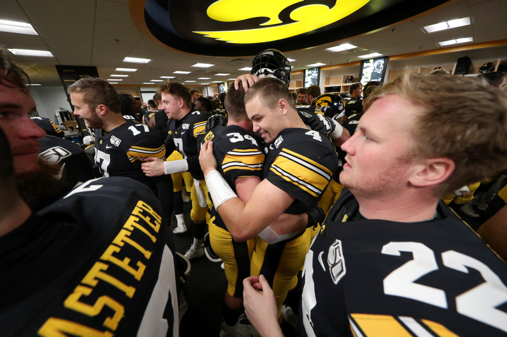 Iowa Hawkeyes quarterback Nate Stanley (4) hugs linebacker Kristian Welch (34) as the celebrate their win against the Illinois Fighting Illini Saturday, November 23, 2019 at Kinnick Stadium. (Brian Ray/hawkeyesports.com)
