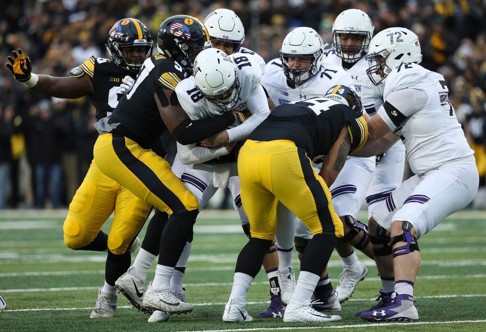 Iowa Hawkeyes defensive end Chauncey Golston (57) and Iowa Hawkeyes defensive end A.J. Epenesa (94) sack the quarterback during a game against Northwestern at Kinnick Stadium on November 10, 2018. (Tork Mason/hawkeyesports.com)
