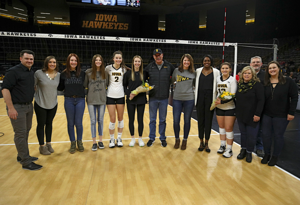 Iowa’s Meghan Buzzerio (5) and Emily Bushman (12) are honored on the court with their families and the coaching staff on Senior Day before their match at Carver-Hawkeye Arena in Iowa City on Saturday, Nov 30, 2019. (Stephen Mally/hawkeyesports.com)
