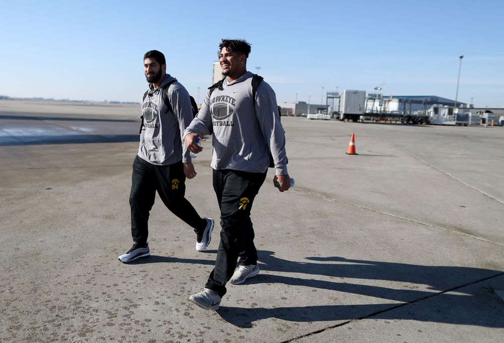 Iowa Hawkeyes defensive end A.J. Epenesa (94) and offensive lineman Tristan Wirfs (74) board the team plane at the Eastern Iowa Airport Saturday, December 21, 2019 on the way to San Diego, CA for the Holiday Bowl. (Brian Ray/hawkeyesports.com)