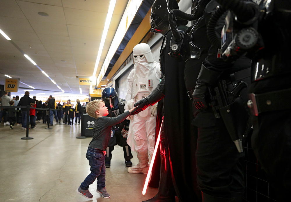 A young Hawkeyes fan gives Darth Vader a high-five on the concourse before the game at Carver-Hawkeye Arena in Iowa City on Sunday, December 29, 2019. (Stephen Mally/hawkeyesports.com)