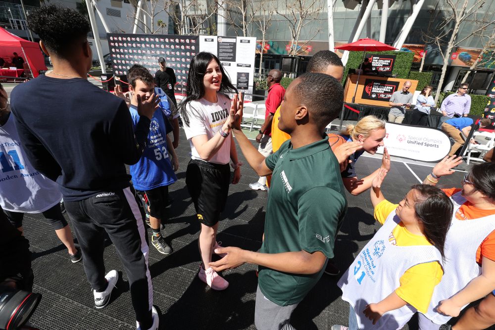 Iowa Hawkeyes forward Megan Gustafson (10) high fives Michigan StateÕs Cassius Winston during a Special Olympics event Friday, April 12, 2019 as part of the ESPN College Basketball Awards in the XBOX Plaza at LA Live. (Brian Ray/hawkeyesports.com)
