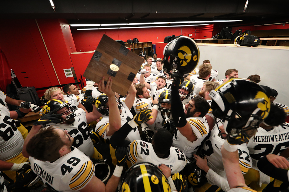 Iowa Hawkeyes quarterback Nate Stanley (4) hoists the Heroes Game trophy as they celebrate their win against the Nebraska Cornhuskers Friday, November 29, 2019 at Memorial Stadium in Lincoln, Neb. (Brian Ray/hawkeyesports.com)
