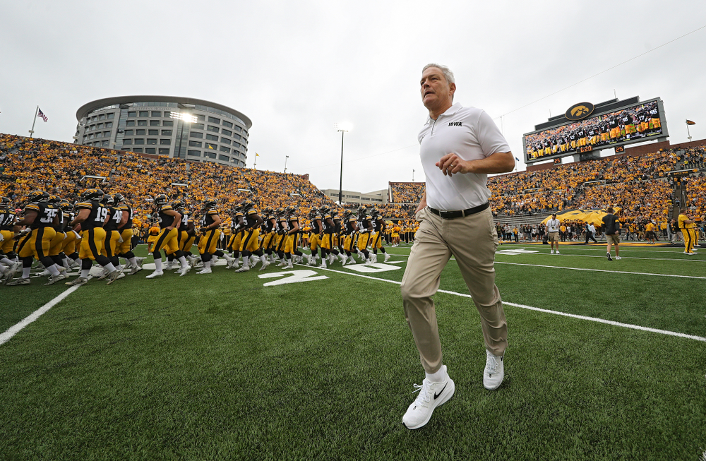 Iowa Hawkeyes head coach Kirk Ferentz runs onto the field as the Hawkeyes swarm as they take the field before their game at Kinnick Stadium in Iowa City on Saturday, Sep 28, 2019. (Stephen Mally/hawkeyesports.com)