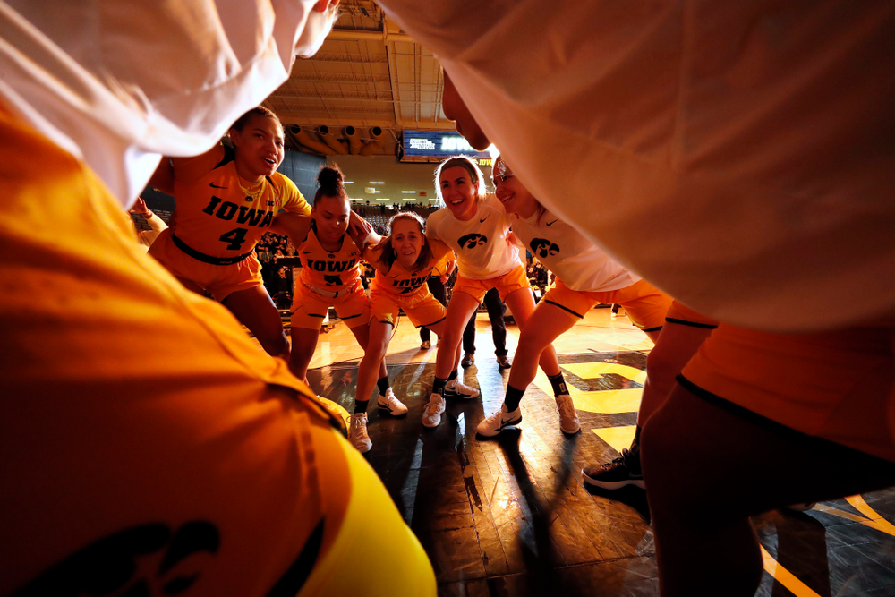 Iowa Hawkeyes forward Chase Coley (4), guard Alexis Sevillian (5), guard Kathleen Doyle (22), and forward Hannah Stewart (21)