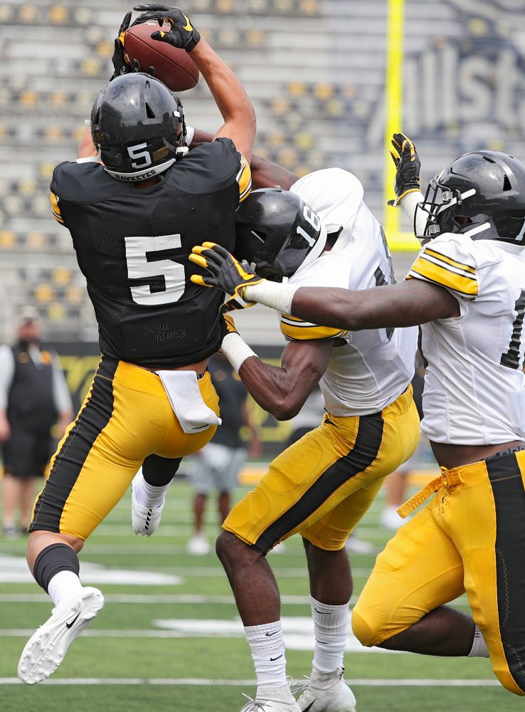 Iowa Hawkeyes wide receiver Oliver Martin (5) pulls in a pass as defensive back Terry Roberts (16) and defensive back Dallas Craddieth (15) defend during Fall Camp Practice No. 8 at Kids Day at Kinnick Stadium in Iowa City on Saturday, Aug 10, 2019. (Stephen Mally/hawkeyesports.com)