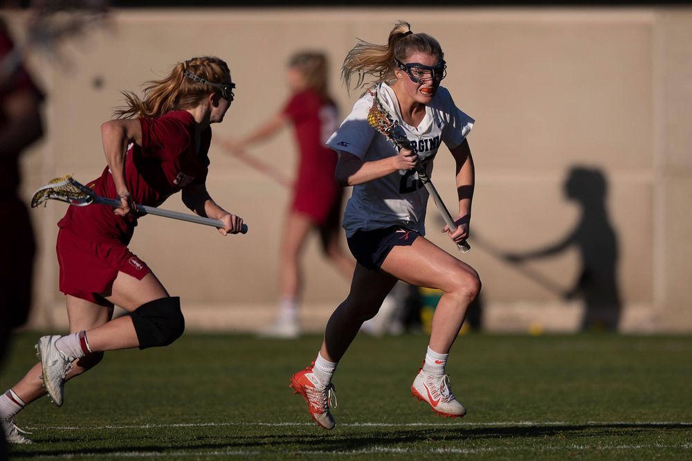 STANFORD, California - FEBRUARY 14: Virginia Cavaliers midfield Courtlynne Caskin (25) is defended by Stanford Cardinal midfield Jacie Lemos (33) during the second half at Cagan Stadium on February 14, 2020 in Stanford, California. The Virginia Cavaliers defeated the Stanford Cardinal 12-11. (Photo by Jason O. Watson)