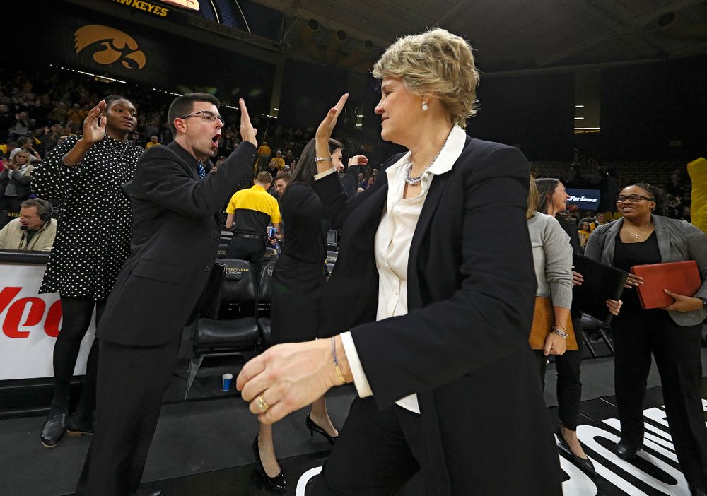 Iowa Hawkeyes head coach Lisa Bluder (right) gets a high-five from Ryan Gruebel, video coordinator and creative director, after winning their game at Carver-Hawkeye Arena in Iowa City on Thursday, January 23, 2020. (Stephen Mally/hawkeyesports.com)