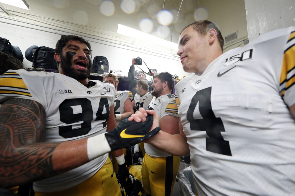 Iowa Hawkeyes defensive end A.J. Epenesa (94) and quarterback Nate Stanley (4) celebrate their victory against the Northwestern Wildcats Saturday, October 26, 2019 at Ryan Field in Evanston, Ill. (Brian Ray/hawkeyesports.com)