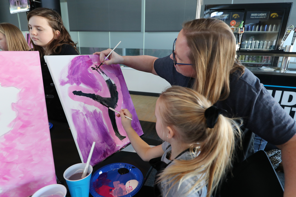 Fans of the GymHawks paint a gymnast with Brush and Barrel before the Iowa Hawkeyes meet against the Minnesota Golden Gophers Saturday, January 19, 2019 at Carver-Hawkeye Arena. (Brian Ray/hawkeyesports.com)